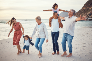 Happy big family, vacation and beach walk for quality bonding time together in the outdoors. Mother, father and grandparents with children playing with smile in happiness for family trip by the ocean
